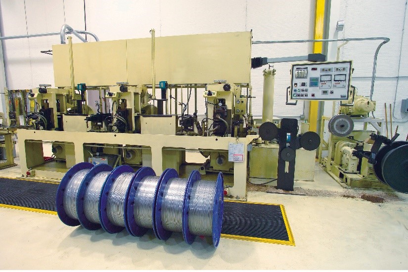 manufacturing process feeding raw round wire through a rolling mill
